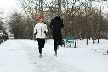 Fototapeta na wymiar Happy people running in winter park. Outdoors sports exercises