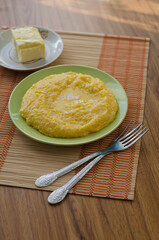 Corn porridge and butter in plates on the table