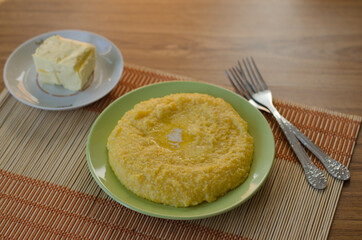 Corn porridge and butter in plates on the table