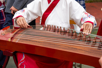 A little girl is playing the guzheng instrument