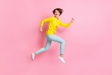 Fototapeta na wymiar Full length body size photo of woman jumping high running fast looking back isolated on pastel pink color background