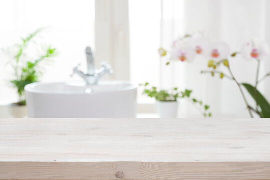 Wooden tabletop for product display on blur bathroom interior background