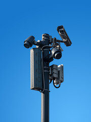 Street surveillance cameras and peripherals are mounted on a pole