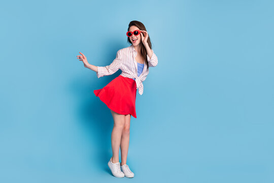 Full length body size view of attractive cheerful girl posing having fun touching specs isolated over bright blue color background