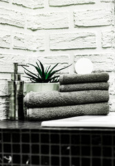 Towels with Liquid Soap on Table in Bathroom.  Mockup for Bathing Products in the Bathroom. Spa Shampoo, Shower Gel, Liquid Soap. Beauty Care Accessories for Bath.