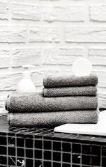 Obraz na płótnie Canvas Towels with Liquid Soap on Table in Bathroom. Mockup for Bathing Products in the Bathroom. Spa Shampoo, Shower Gel, Liquid Soap. Beauty Care Accessories for Bath.