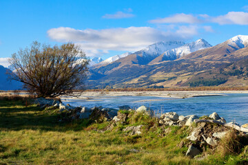 The Dart River in the Otago region of New Zealand's South Island, with the snow-capped mountains of the Southern Alps in the background