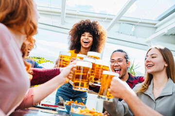 Happy multiracial friends group drinking beer at brewery pub restaurant - Friendship concept with...