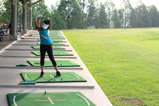 Women player golf swing shot on course or Girl golf player with driver shoot over lake, view from behind.