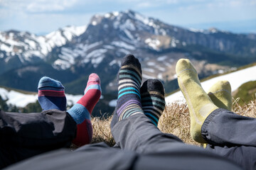 Detail photo with hikers feet and their colored socks relaxing on a mountain peak