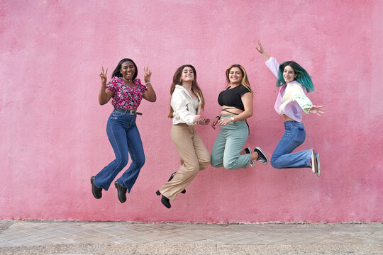 Four Multiethnic Pretty Girl Friends Jumping Happy