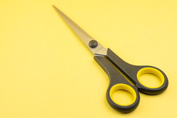 Household scissors on a yellow background