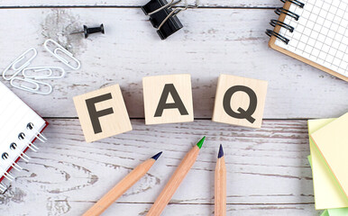 FAQ text on wooden block with office tools on the wooden background - obrazy, fototapety, plakaty