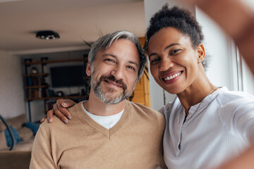 Two adult lovers, taking pictures with phone, at home.