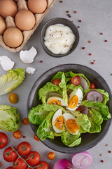 Diet menu. Healthy salad of fresh vegetables - tomatoes, egg, Onion. high angle view of a nutritious vegetable salad with boiled egg slices, served.  Healthy meal concept.