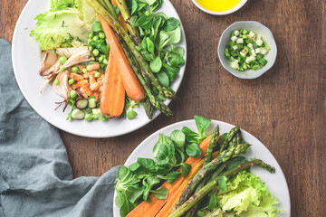 Spring, summer vegetarian  rustic, village salad with balanced ingredients: proteins, fiber and fat. Greens, asparagus and carrots, grilled onions, fresh peas, baked beans, dressing with olive oil 