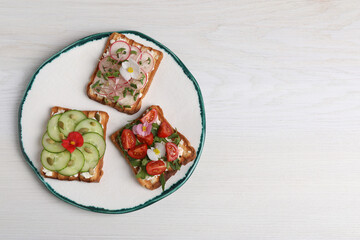 Different delicious sandwiches on white wooden table, top view. Space for text