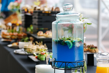 Blue matcha tea in the glass vessel on the background of a food court. 