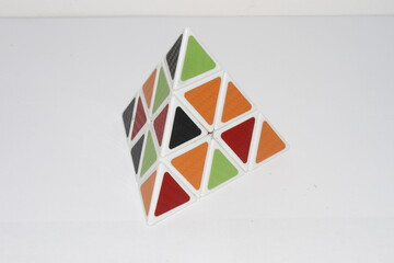 Pyraminx . collection of Rubik's cube puzzles and other puzzles, geometric shapes of pyramids, disassembled Rubik's cube . Pyramid and Rubik's cube  - obrazy, fototapety, plakaty