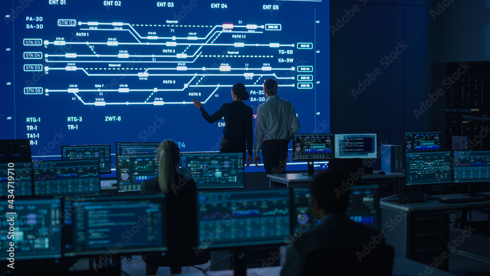 Aufkleber Project Manager and Computer Science Engineer Talking while Using Big Screen Display Showing Infrastructure Infographics and Data.Telecommunications Control Monitoring Room with People Working