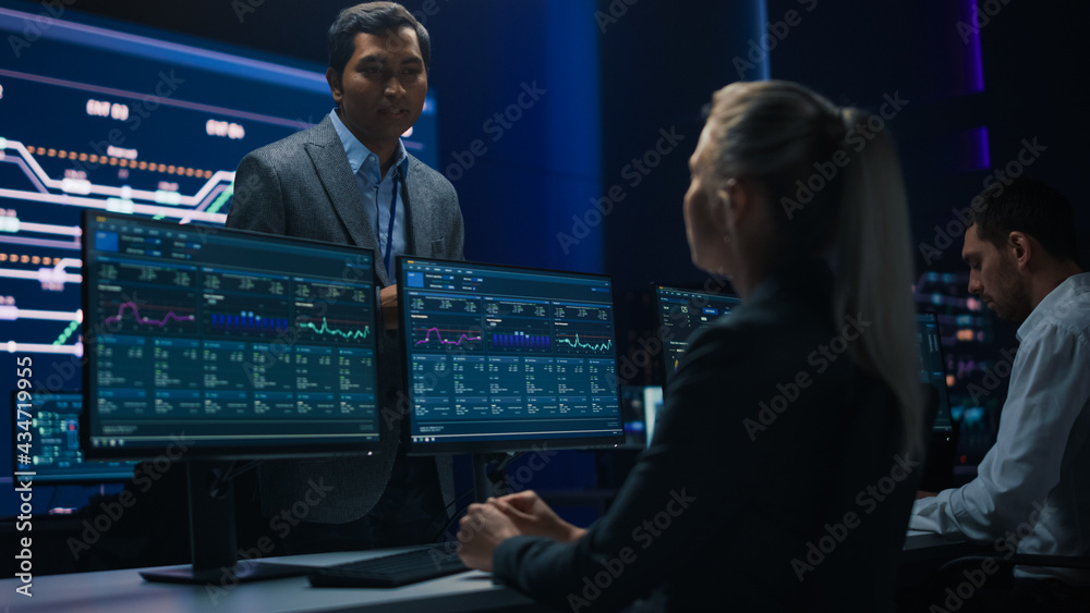 Poster confident female specialist works on computer talks with team leader in big infrastructure control r