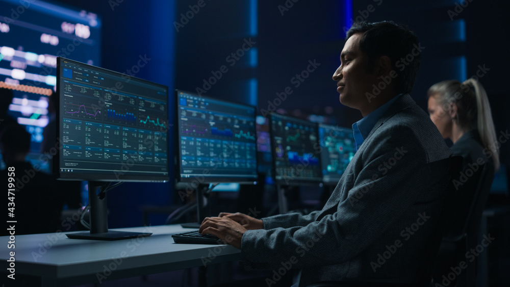 Aufkleber Confident Male Data Scientist Works on Personal Computer in Big Infrastructure Control Room. Stock Market Male Specialist Uses Computer Showing Charts, Information. Monitoring Room Team