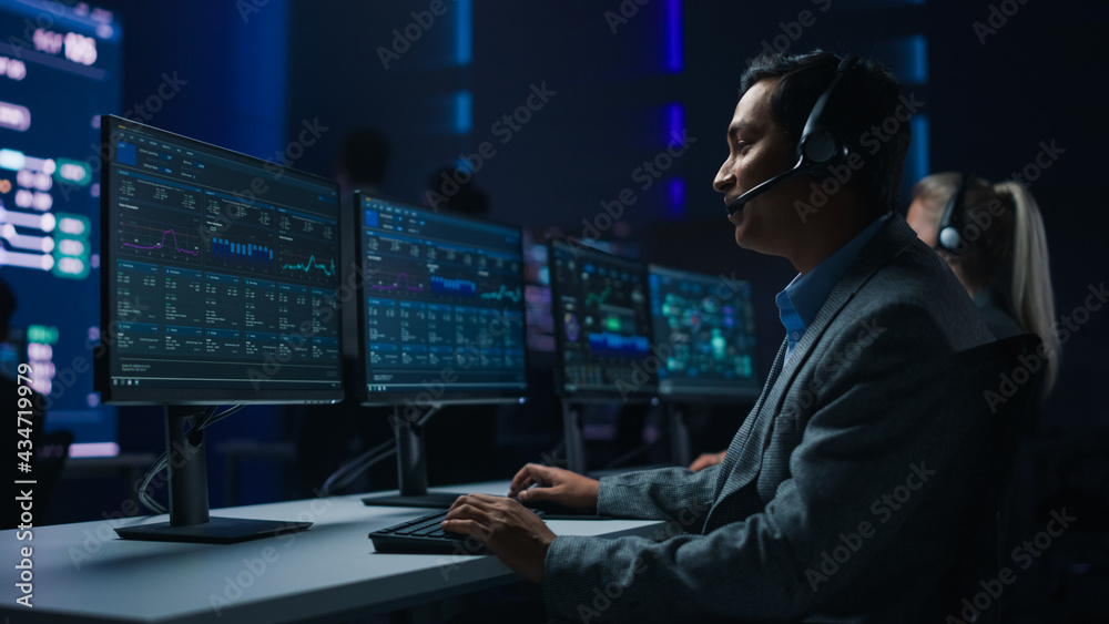 Poster professional customer support specialist wearing headset talks with client and works on computer in 