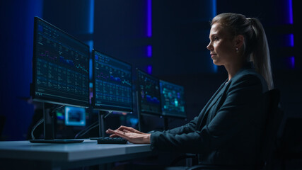 Confident Female Data Scientist Works on Personal Computer in Big Infrastructure Control Room. Stock Market Woman Specialist Uses Computer Showing Graphs, Charts, Information. Monitoring Room Team