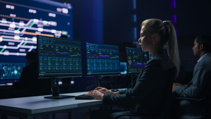 Confident Female Data Scientist Works on Personal Computer in Big Infrastructure Control Room. Team...