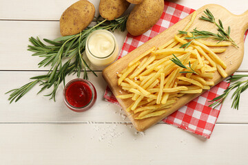 Flat lay composition with french fries and potatoes on white wooden table