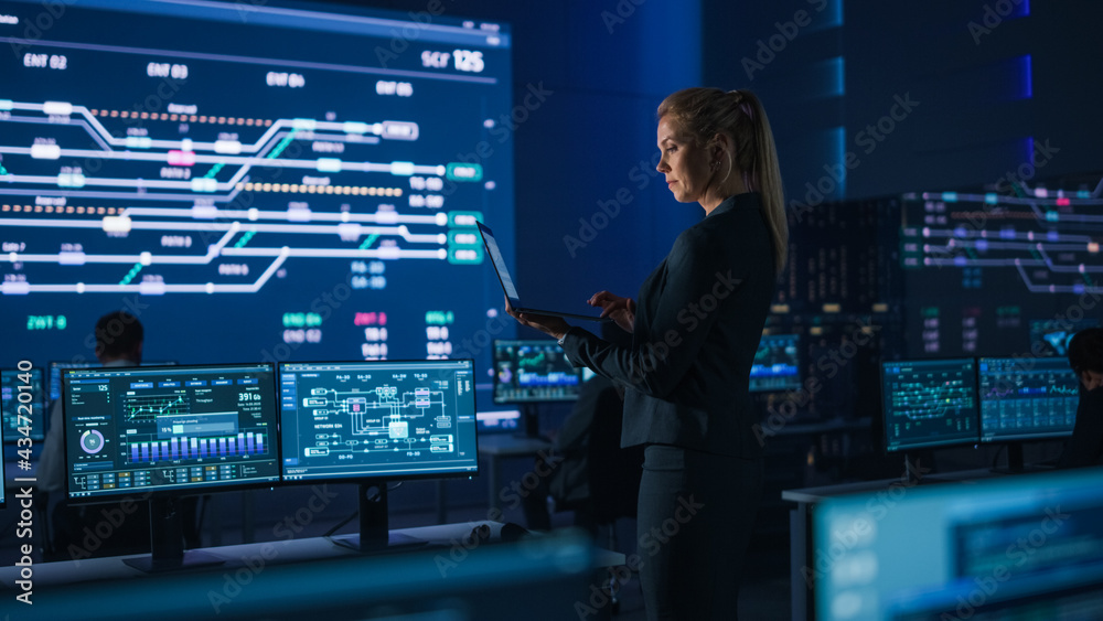 Poster beautiful confident female project manager works on a laptop standing in telecommunications system c