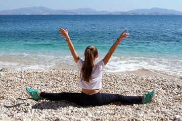 jeune fille pratiquant de l'exercise physique sur une plage
