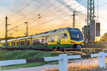 Modern electric train travelling at sunset