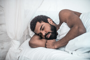 African american sound asleep in white bed