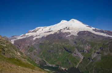 Elbrus is the highest mountain in Europe. Elbrus is located in the south-east Caucasus mountain range in Kabardino-Balkaria, Russia. View from Cheget mount. July. Panoramic view from Cheget peak