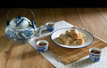 Duck Neck Snacks in white dish, and Chinese tea,  Dessert of Chinese put on bamboo mat and brown...