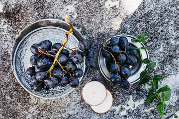 Grappe de raisin noir fraichement cueillis dans la vigne posé sur une table texturé