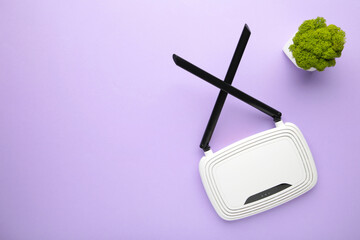 Wireless Wi-Fi router on purple background with copy space