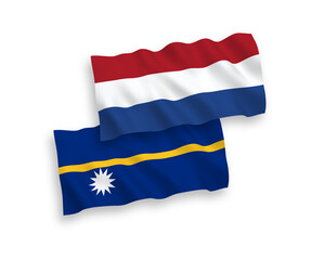 National vector fabric wave flags of Republic of Nauru and Netherlands isolated on white background. 1 to 2 proportion.