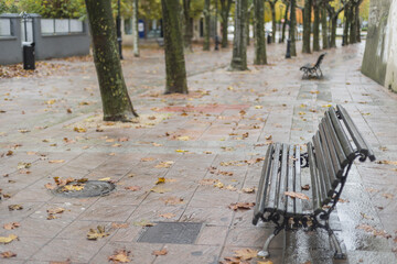 Empty sidewalk benches on a rainy day in the medieval city of Hervas, Caceres, Spain