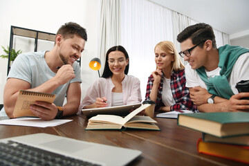 Young people discussing group project at table in library