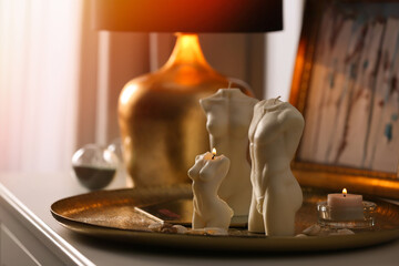 Beautiful body shaped candles on table indoors