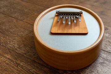 Wooden instrument Sansula or kalimba with membrane on a wooden floor background with copy space.