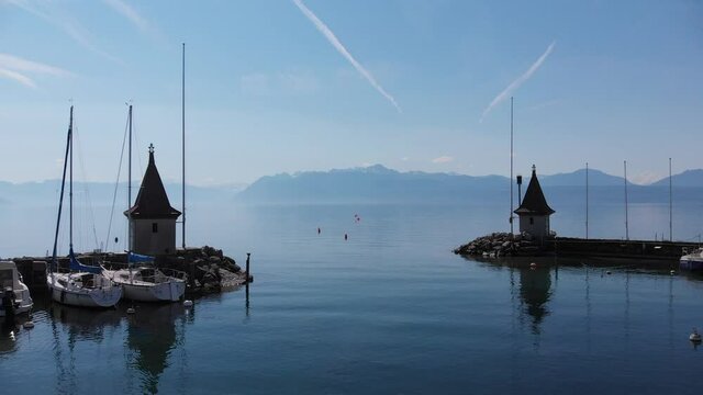 Flying through gates of port of Morges to Geneva Lake with Alps on Background