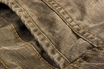 clothing items stonewashed cotton fabric texture with seams, clasps, buttons and rivets, macro