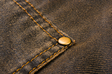 clothing items stonewashed cotton fabric texture with seams, clasps, buttons and rivets, macro