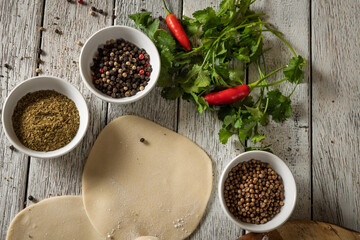 Close up to Caucasian khinkali dumplings dish served on plate. Background with ingredients and scattered spices