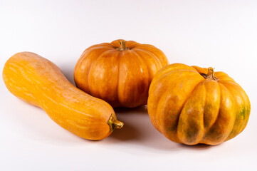 Three whole fresh orange big pumpkin on white background, closeup. Organic agricultural product, ingredients for cooking, healthy food vegan.