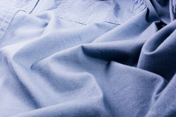 clothing items stonewashed cotton fabric texture with seams, clasps, buttons and rivets, macro