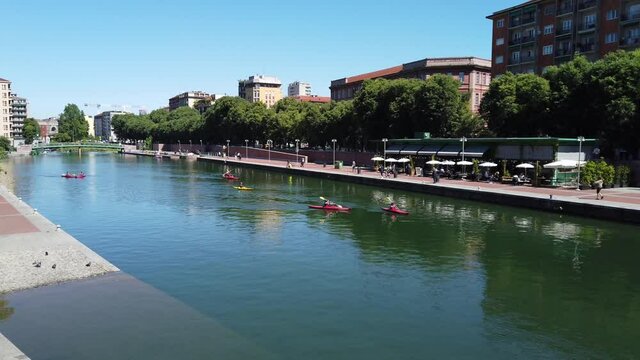 Europe, Italy , Milan May 2021 - Darsena and Navigli canals with people doing aquatic sports , canoeing  after finish of lockdown due Covid-19 Coronavirus epidemic